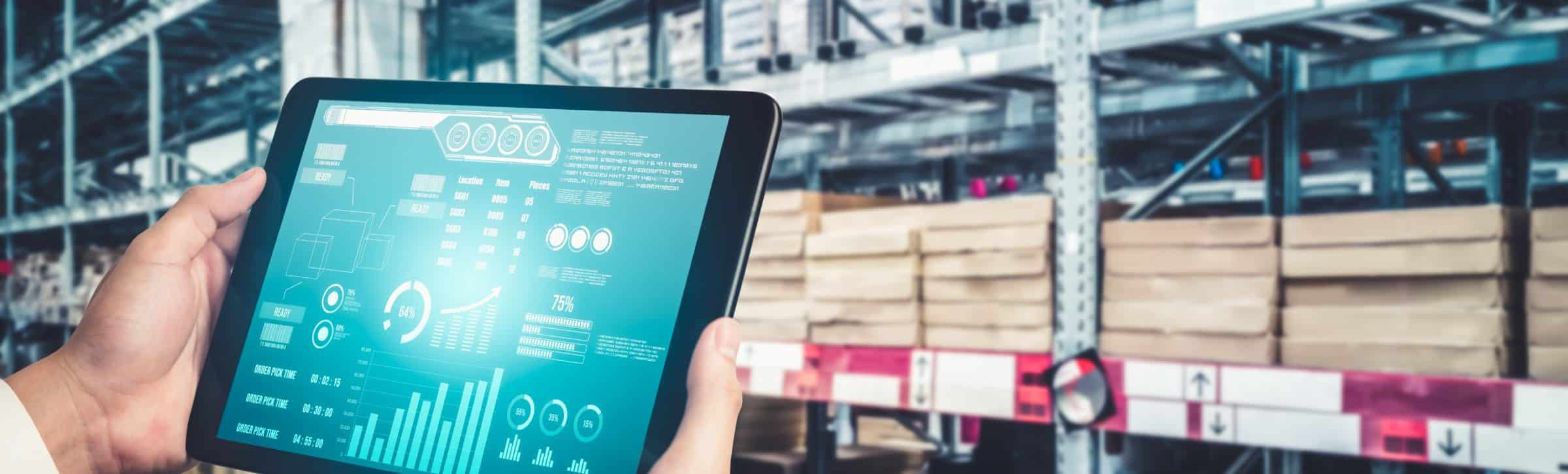 Worker in a warehouse looking at a tablet full of data